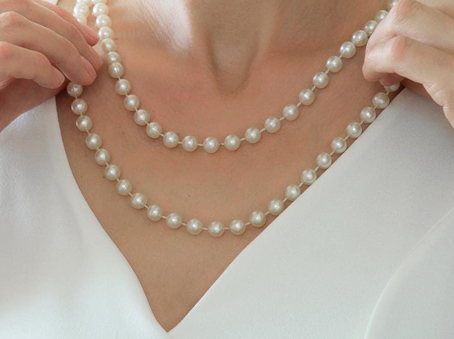 A woman wearing a pearl necklace, showcasing elegance and style.